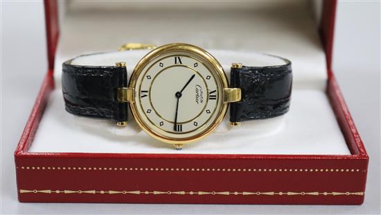 A ladys silver gilt Must de Cartier quartz wrist watch, with Cartier leather strap with deployment clasp and Cartier box.